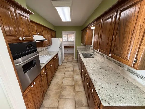 a kitchen with sink window and stainless steel appliances