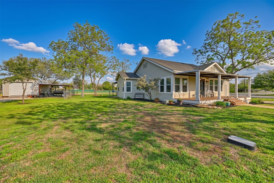 407 North Summit Street Weimar, TX 78962 - Photo 18 of 24 a front view of a house with a garden and trees
