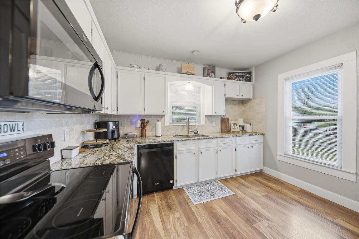 407 North Summit Street Weimar, TX 78962 - Photo 6 of 24 a kitchen with a sink stove and cabinets
