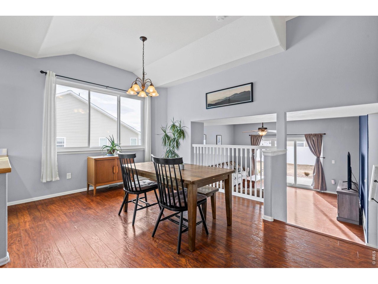 6963 Lee Street Wellington, CO 80549 - Photo 3 of 24 Bright and airy dining space with vaulted ceilings, large windows, and an open-concept layout.