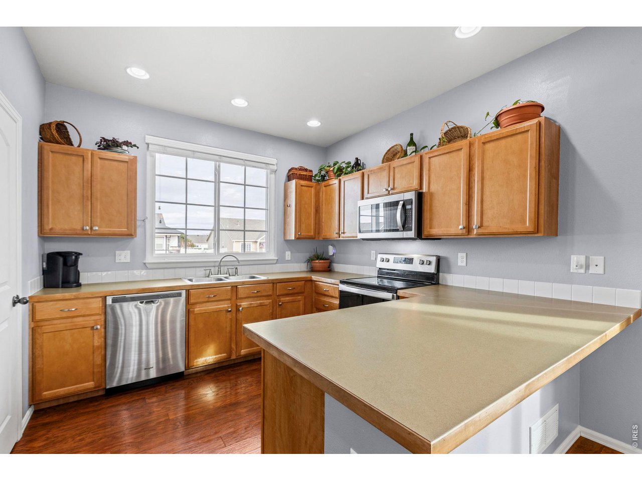 6963 Lee Street Wellington, CO 80549 - Photo 5 of 24 Functional kitchen featuring ample cabinetry, stainless steel appliances, and breakfast bar for prep and gathering.