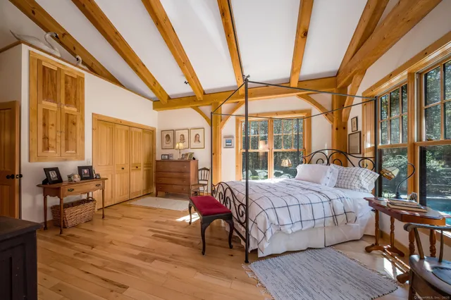 a bedroom with a bed and wooden floor