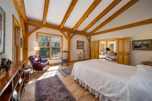 a spacious bedroom with a bed a flat screen tv and balcony