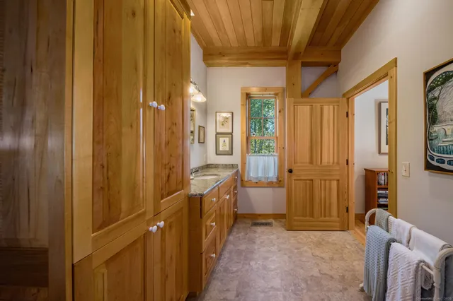 a view of a hallway with bathroom and glass door