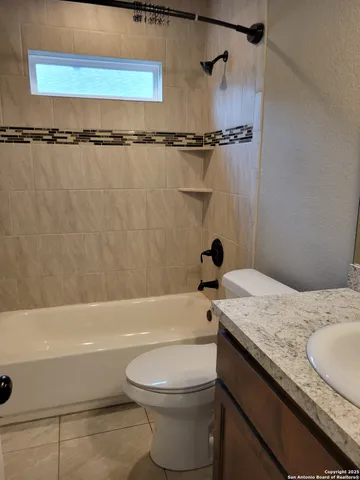 a bathroom with a granite countertop sink toilet and bathtub