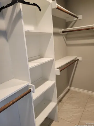a view of walk in closet with clothes