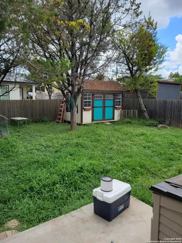 a backyard of a house with yard and trampoline