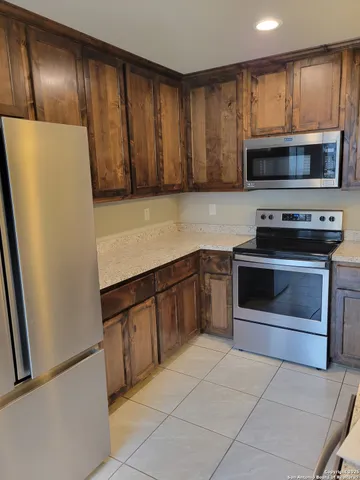 a kitchen with granite countertop a refrigerator stove and microwave