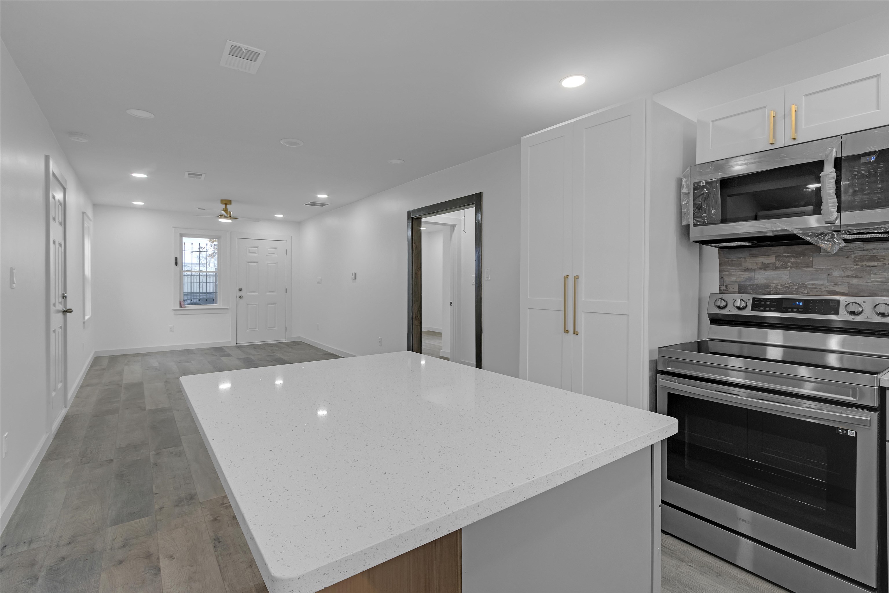 2881 Tutwiler Avenue Memphis, TN 38112 - Photo 11 of 23 Kitchen with appliances with stainless steel finishes, recessed lighting, light stone counters, decorative backsplash, and white cabinetry