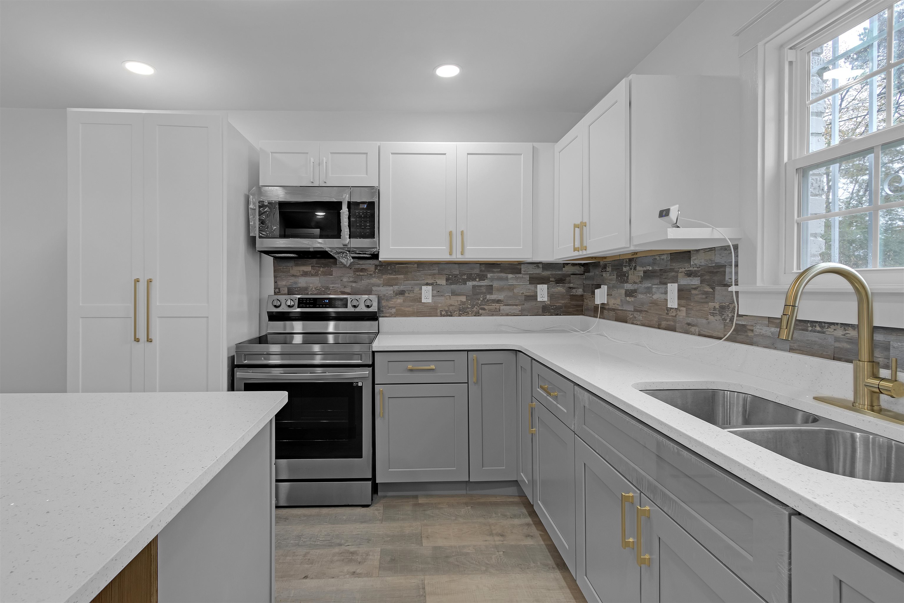 2881 Tutwiler Avenue Memphis, TN 38112 - Photo 12 of 23 Kitchen featuring stainless steel appliances, light stone countertops, light wood-style flooring, white cabinetry, and recessed lighting