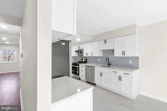 a large kitchen with a stove a sink and a refrigerator