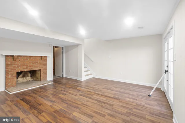 a view of empty room with wooden floor and fireplace