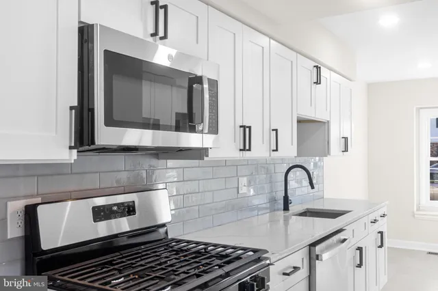 a kitchen with kitchen island a sink stove and cabinets