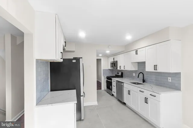 a kitchen with stainless steel appliances a refrigerator sink and cabinets