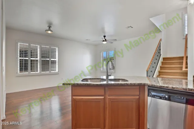 a kitchen with granite countertop a stove a sink and a wooden floors