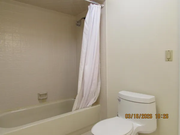 a bathroom with a granite countertop toilet and a sink