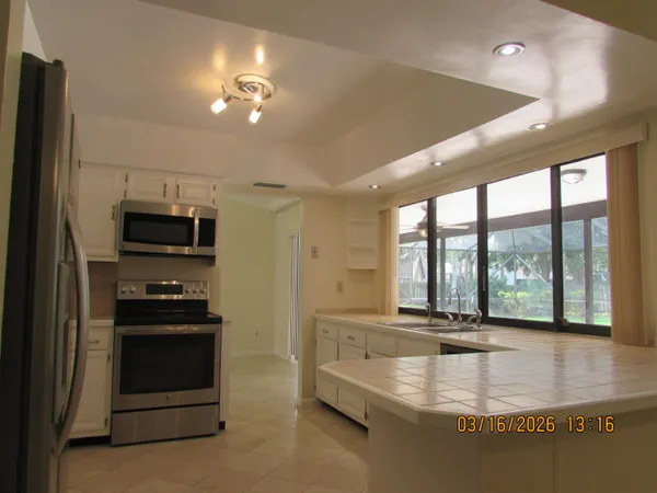 a view of a kitchen with stainless steel appliances granite countertop a stove and a refrigerator