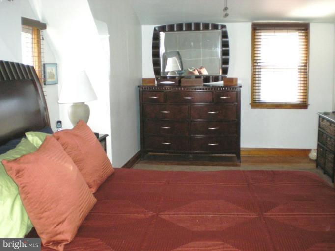 2115 Stonewall Road Catonsville, MD 21228 - Photo 13 of 19 a bedroom with a bed and wooden floor