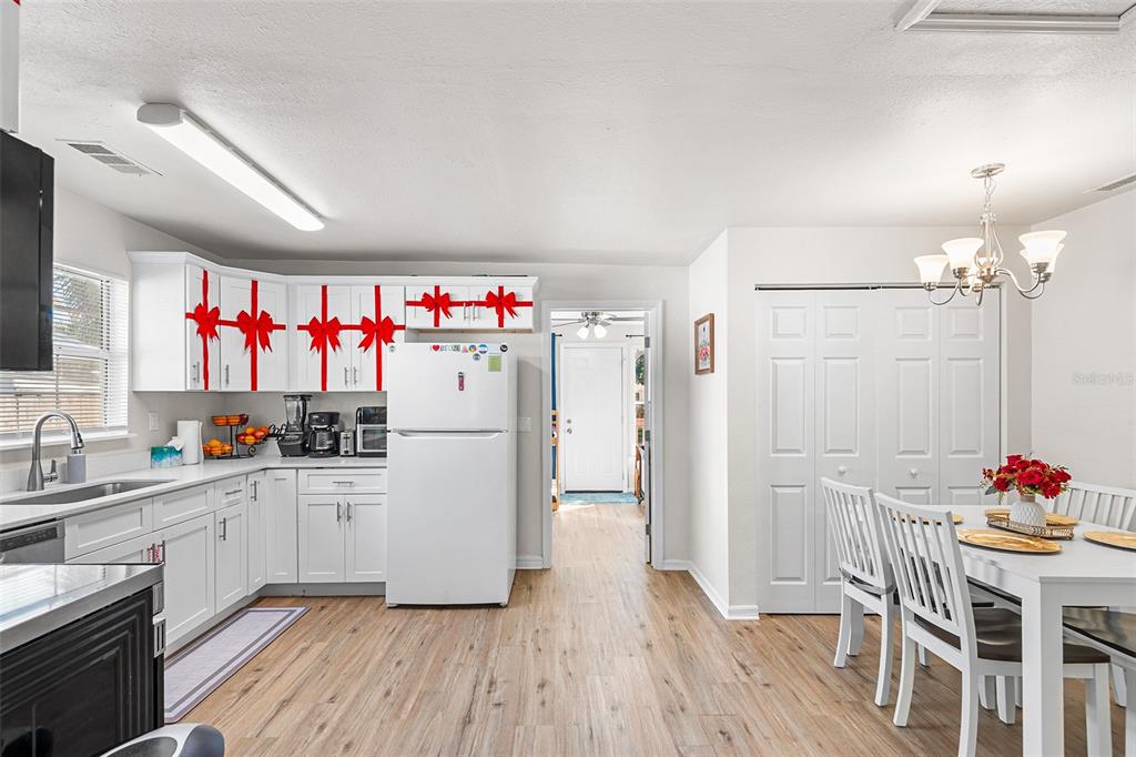 515 Walnut Street Auburndale, FL 33823 - Photo 10 of 43 a kitchen with a sink dishwasher a refrigerator and a dining table with wooden floor