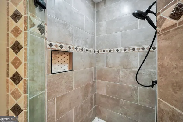 a spacious bathroom with a double vanity sink a mirror and a shower