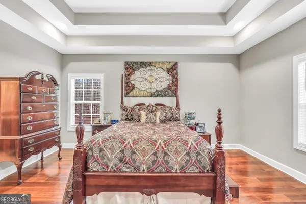 a spacious bedroom with a bed and flat screen tv