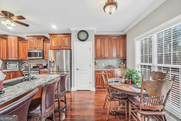 a kitchen with stainless steel appliances granite countertop a refrigerator a stove and a sink