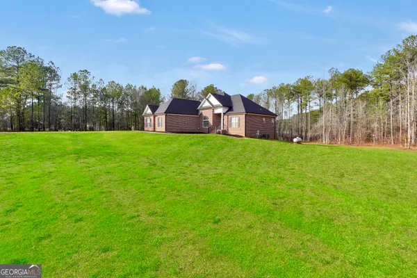 a view of a big yard with a house in the background