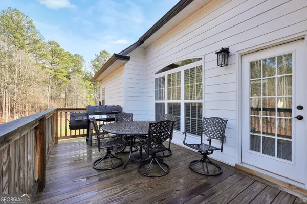 a view of a roof deck with table and chairs and wooden floor