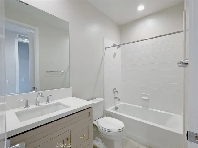 a bathroom with a granite countertop sink a toilet and shower