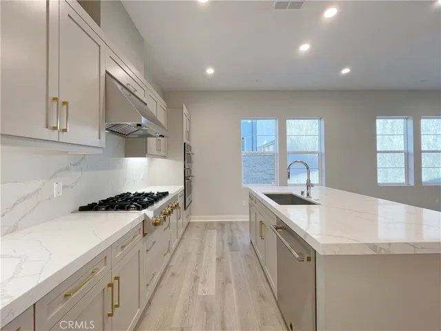 a kitchen with granite countertop a sink stove and cabinets