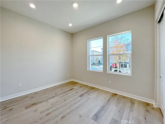 an empty room with wooden floor and window