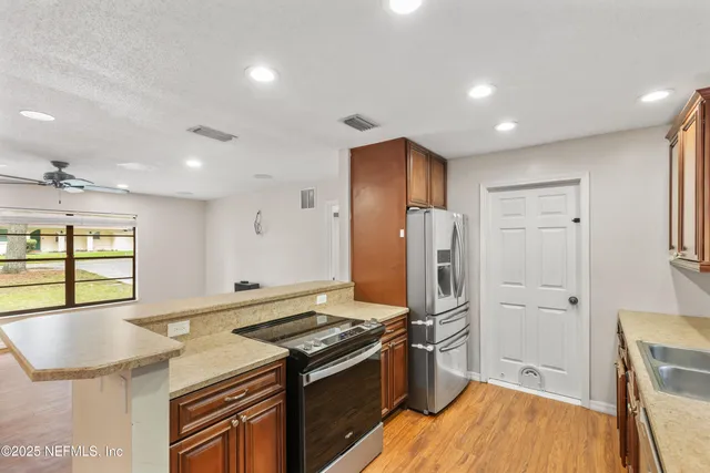 a kitchen with stainless steel appliances granite countertop a refrigerator and a stove