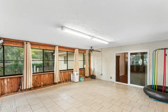 an empty room with windows and chandelier