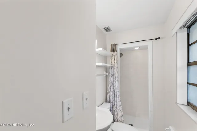 a bathroom with a shower and a toilet