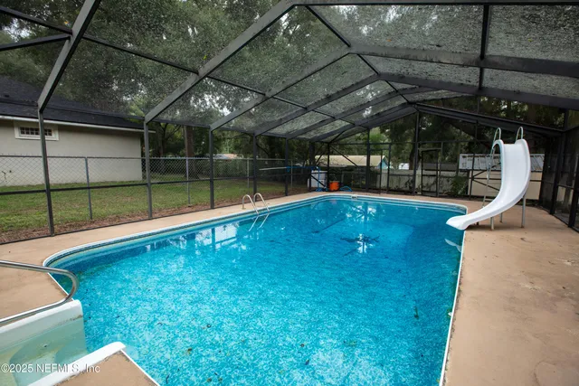 a swimming pool with a yard and outdoor seating