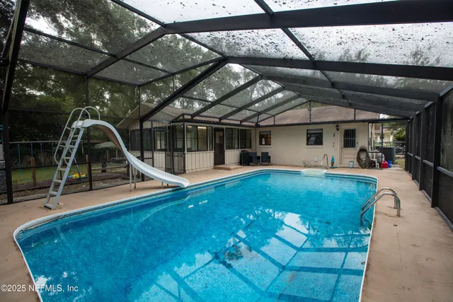 a view of a swimming pool with a patio and a garden