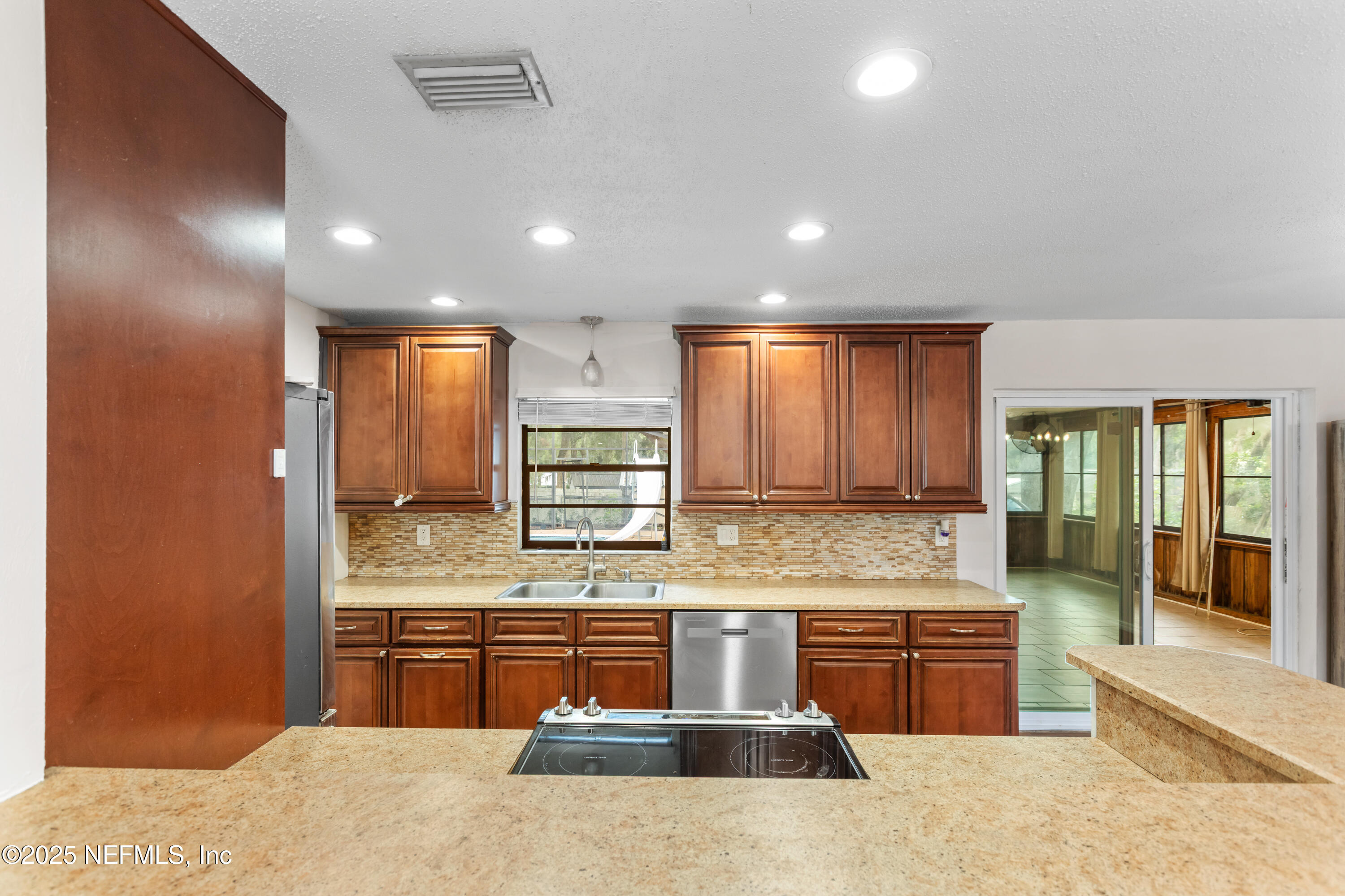 220 Southwest Grove Street Keystone Heights, FL 32656 - Photo 9 of 41 a kitchen with stainless steel appliances kitchen island granite countertop a stove a sink and a refrigerator