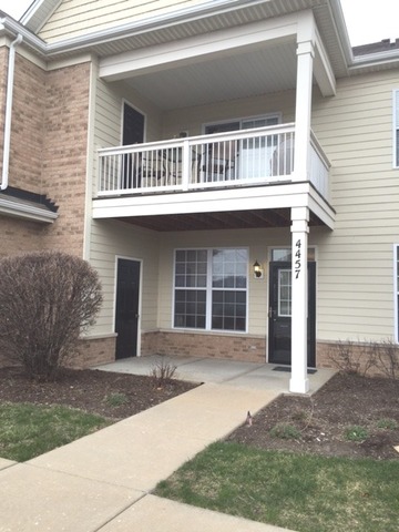 4457 Timber Ridge Court, Unit 4457 Joliet, IL 60431 - Photo 2 of 3 a front view of a house with a yard