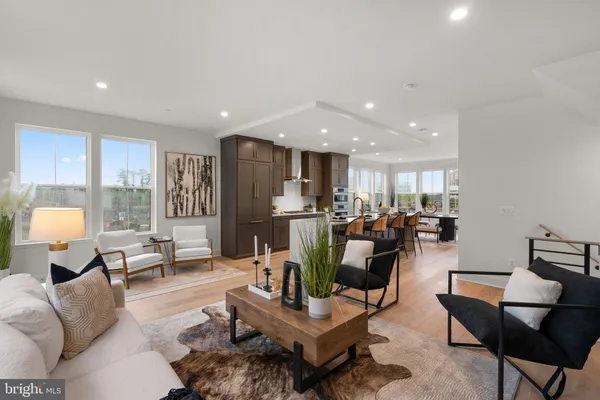 a living room with furniture kitchen view and large windows