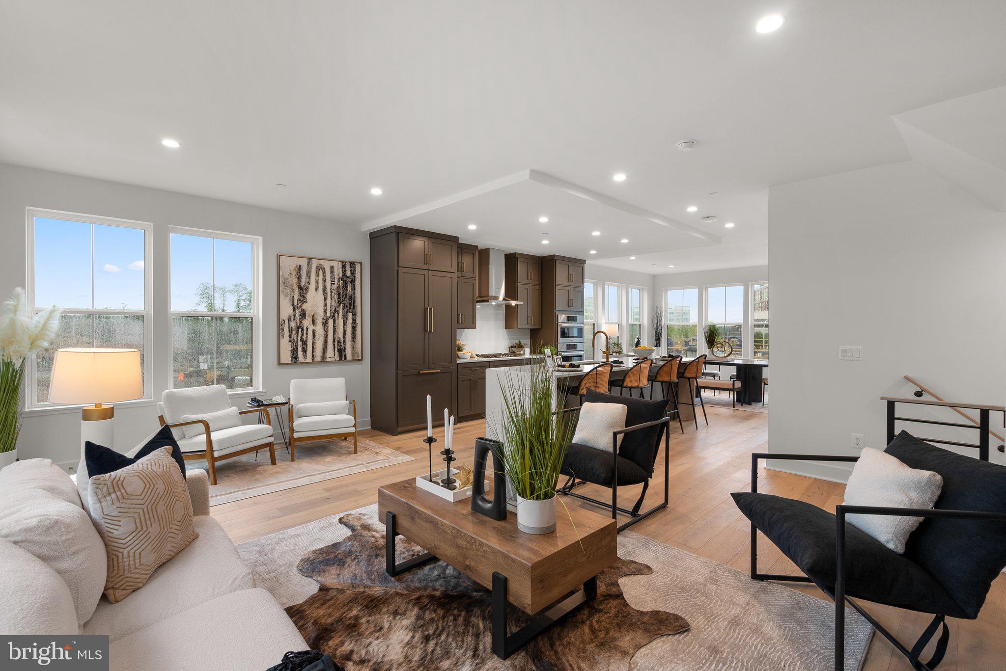 a living room with furniture kitchen view and large windows