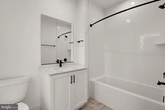 a bathroom with a granite countertop sink mirror toilet and bathtub