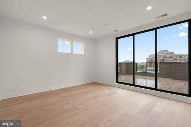 an empty room with wooden floor and sliding glass door