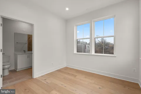 a view of an empty room with a window and bathroom