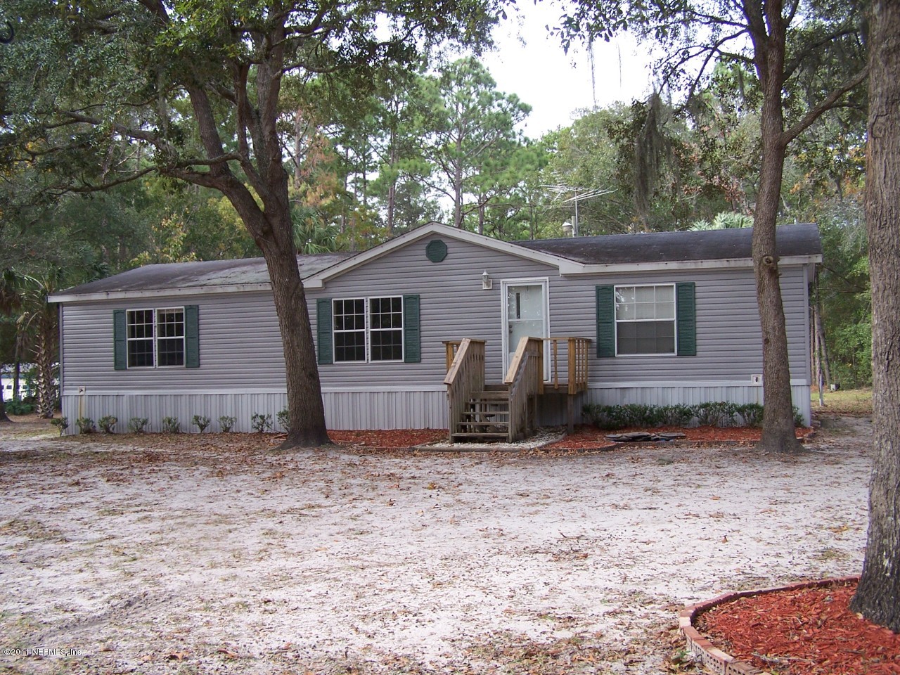 87471 Haven Road Yulee, FL 32097 - Photo 1 of 5 a white house that has a tree in front of it