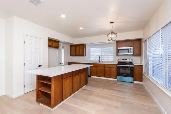 a large kitchen with stainless steel appliances granite countertop a stove and cabinets
