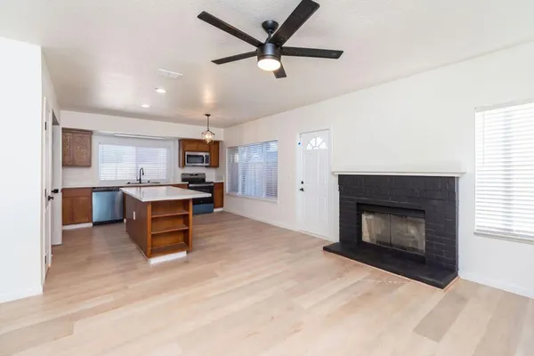 a living room with stainless steel appliances kitchen island a fireplace and a television