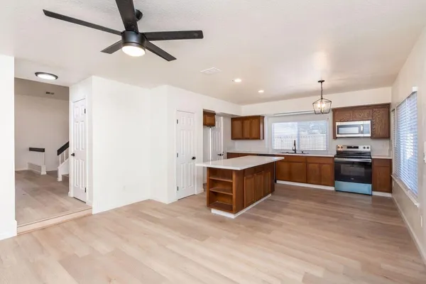 a kitchen with stainless steel appliances kitchen island granite countertop a refrigerator and a sink
