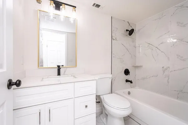 a bathroom with a sink toilet vanity and tub