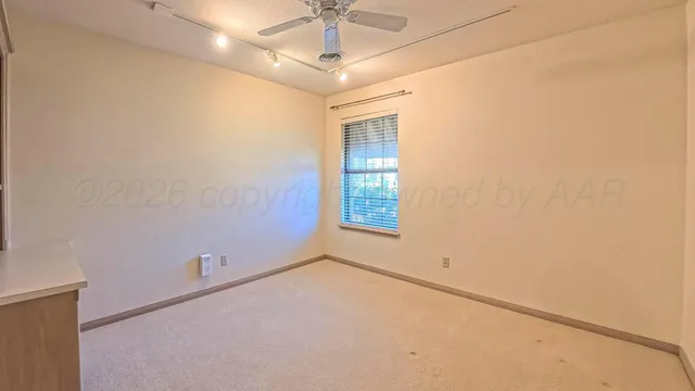 a view of an empty room with closet and a window
