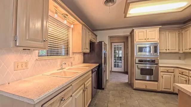 a kitchen with cabinets appliances and a window